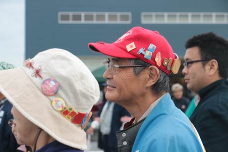 帽子に各地の凧のバッジをつけた凧愛好者