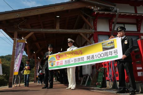 横断幕を掲げて100周年記念号を待つ