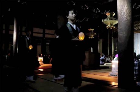 あかりを手に正信偈を唱えながら歩く三条教区の僧りょ