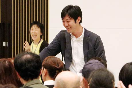 来場者と握手して退場する石川氏