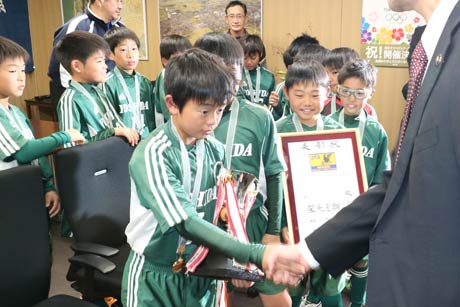 鈴木市長と握手する吉田サッカークラブの選手たち