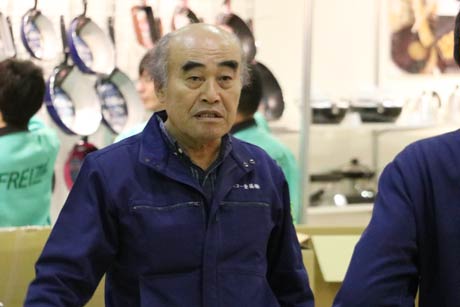 社員とともに自社のブースの展示作業を行う田野燕商議所会頭