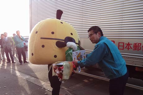 JAにいがた南蒲のゆるきゃらマスコット「梨之助」から4トントラックで加茂産のナシを長野県長野市に運ぶドライバーにナシなどを手渡す