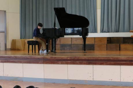 臨時全校朝会で全校児童の前で演奏を披露する高橋君