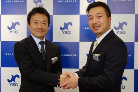 福田会長(左)と握手する佐藤次年度会長