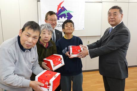 利用者にケーキを手渡すローソン燕杣木店のオーナー長岡さん(右)