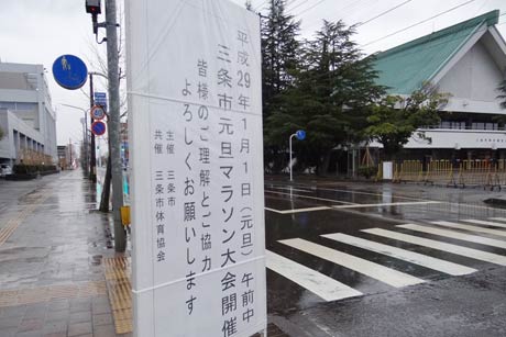 スタート地点となる三条市総合福祉会館前に設置された三条市元旦マラソン大会に対する協力を求める看板