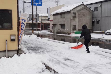 スノーダンプで店の前を除雪する市民