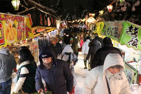 雪が電球のあかりを反射して明るい境内