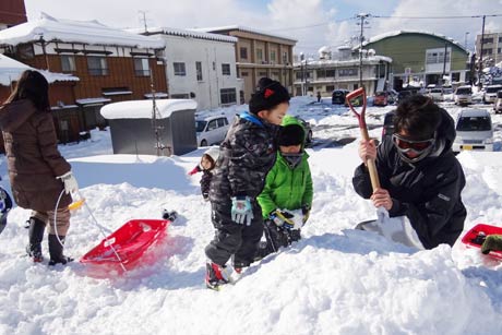 一ノ木戸ポプラ公園で雪遊びする親子