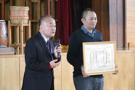 三条小PTAが受けた平成28年度優良PTA文部科学大臣表彰を表彰状を披露して紹介する小林校長(左)と原田PTA会長