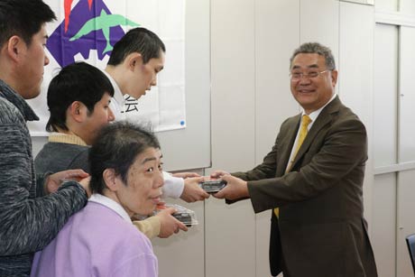 利用者に恵方巻を手渡すローソン燕杣木店の長岡オーナー