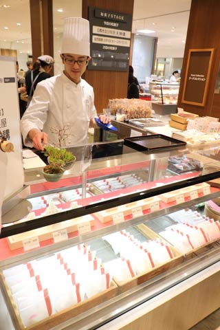 新潟伊勢丹で開かれている「越後つばめ天神講菓子展」で天神講の菓子を販売する白根屋の更科さん