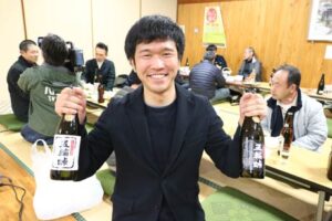 完成した下田産本格芋焼酎「五輪峠」を手に「芋主プロジェクト」に中心となって担当した地域おこし協力隊の大滝さん
