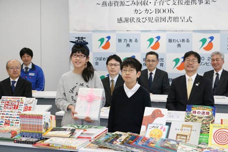 贈呈した絵本を前に小池小5年山崎さん(左)と同4年野中さん