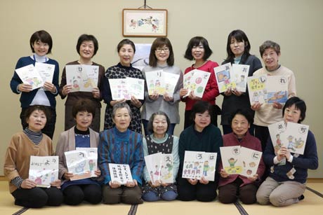  制作した「つばめ食育かるた」と燕市食生活推進委員協議会の「つくり隊」メンバー