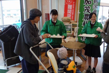 来店客におにぎりを手渡す