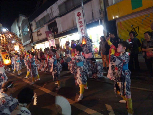 商店や氏子の自宅で、踊りと唄を披露する門付けかどづけ。外から見るとこのように、若連中が狭い店内になだれこんでいるように見える。