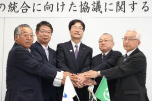 水道事業の統合に向けた協議に関する覚書を交わして握手する鈴木燕市長(左から3人目)と小林弥彦村長(左から4人目)ら