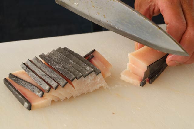 二・七の定期市でクジラ肉をさばく鮮魚店の主人