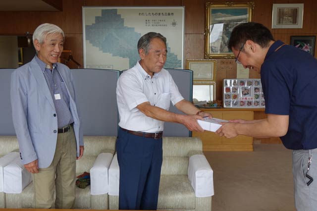  三条クラフトフェア実行委員会の高橋会長から国定市長に寄付を手渡す
