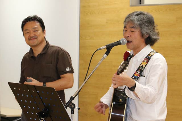 挿入歌を歌う矢代秀晴さん(右)と飛び入り出演の坂口作弥さん