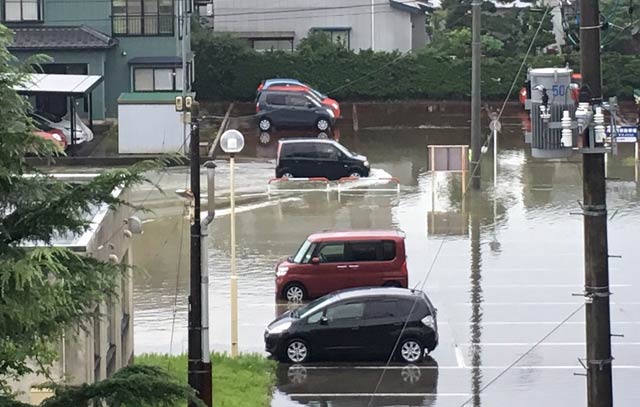 読者提供写真。原信四日町店裏の南四日町の公営団地。駐車場がひざ下までの水で冠水した。