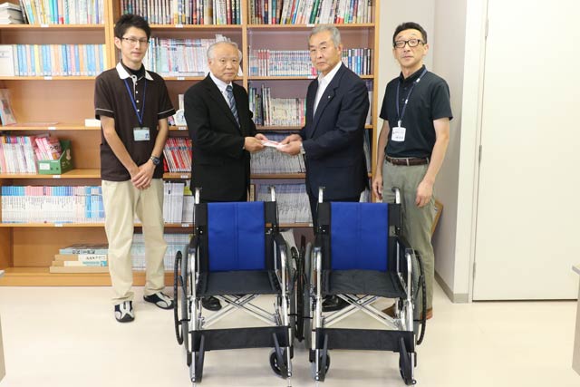  寄付した車いすと左から2人目が有限会社家具のまるやまの丸山社長、3人目がつばめ福祉会の吉田理事長