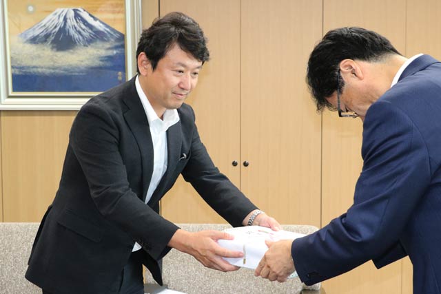特殊詐欺防止メッセージ入り印鑑マットを鈴木市長に手渡す燕市金融機関防犯連絡協議会会長の第四銀行燕支店・神子島支店長