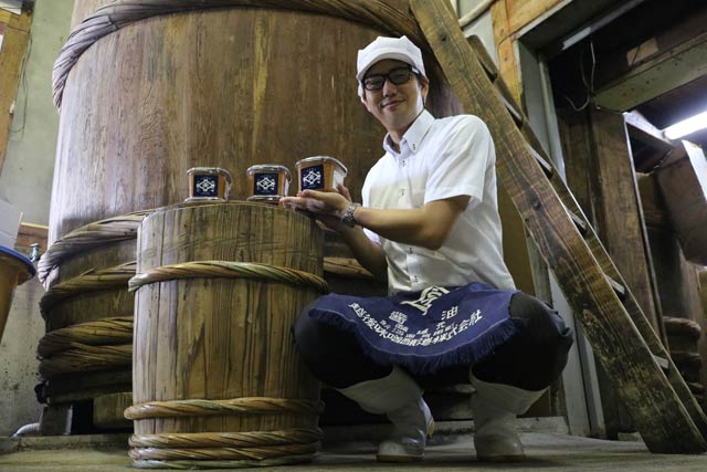 木龍社長と後ろは新たに1800kgの「十割米麹味噌」を仕込んだ木おけ