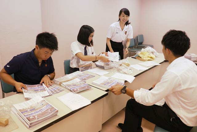 パンフレットを準備する慶応と明治の学生