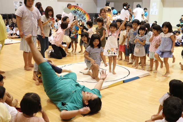  保育園児に投げられてひっくり返る力士