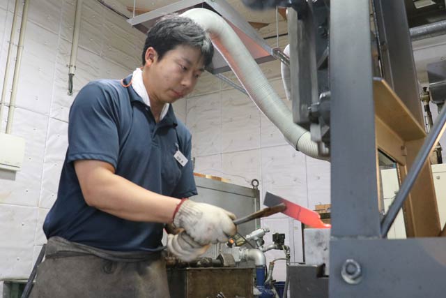 赤くなるまで熱した材料をたたく鍛造作業