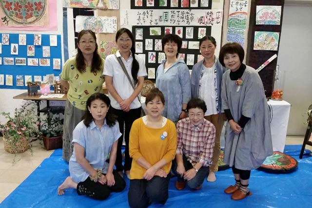 燕市下水終末処理場で制作実演を行っている土田正子さんと絵手紙教室の生徒たち