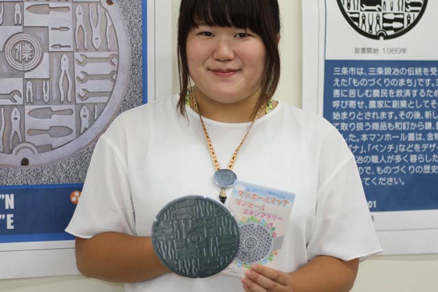 マンホールスタンプラリーのコンプリートの特製記念品の三条市のマンホールのふたをデザインした巨大缶バッジとスタンプラリーの台紙