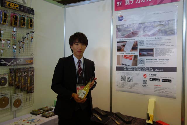 【株式会社ナガオカ・リコー】商品に表示する2次元（2Dシンボル）・GS1QRと呼ぶQRコードにより、スマホなどで読み込むだけで取り扱い説明書や商品情報を表示でき、リコール情報などもプッシュ送信できるシステムを紹介。日本酒輸出用など食品への表示も提案。
