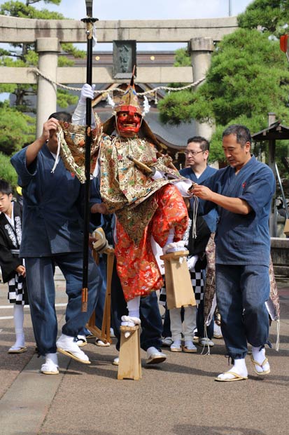 ダイナミックに足を上げて歩を進める天狗