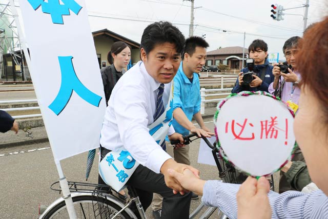 自転車で街頭演説に出発する鷲尾氏