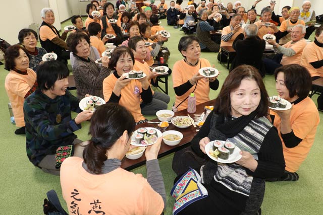自分で完成させた「にこまき」を掲げて記念写真