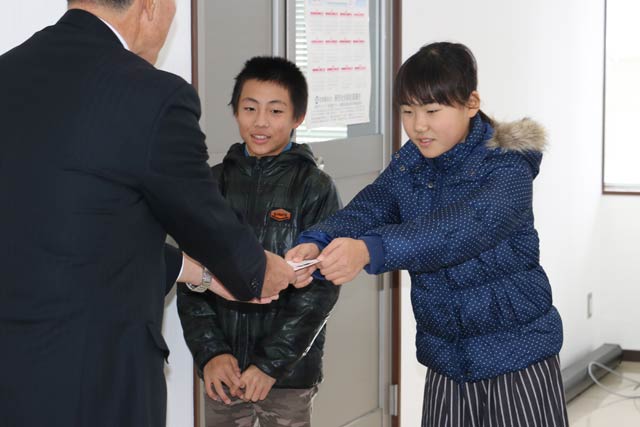 赤い羽根の校内募金に寄せられた善意1万4,226円を新潟県共同募金会燕市共同募金委員会に寄付する体育ボランティア委員会の6年生2人