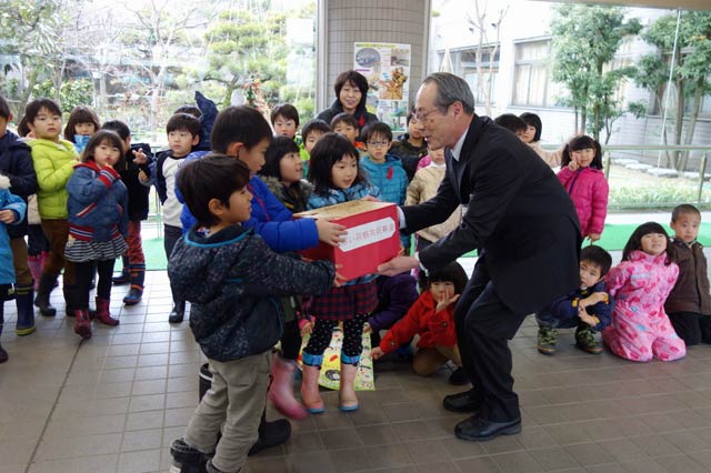 三条市社会福祉協議会の渡辺事務局長に赤い羽根共同募金の寄付を手渡す「ふじの木保育園」年長児