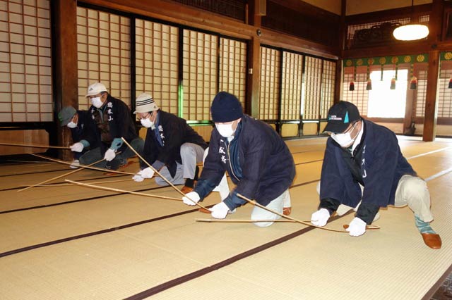 法華宗総本山本成寺のすす払いでタケ棒で畳のほこりをたたき出す