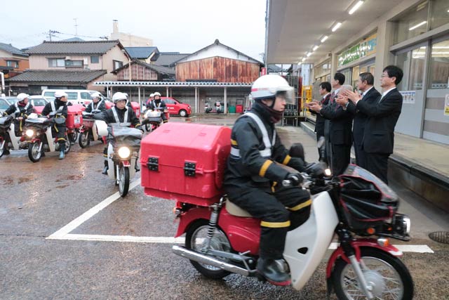 バイクに乗って配達に出発する配達員