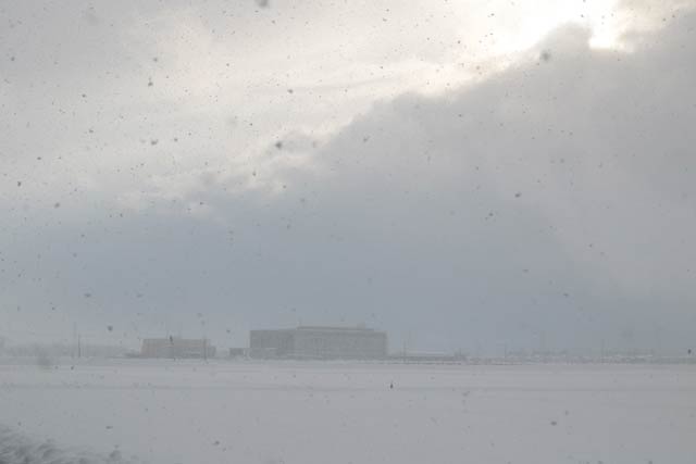 大雪に燕市役所もかすんで見えるが雲の切れ間から日が差す