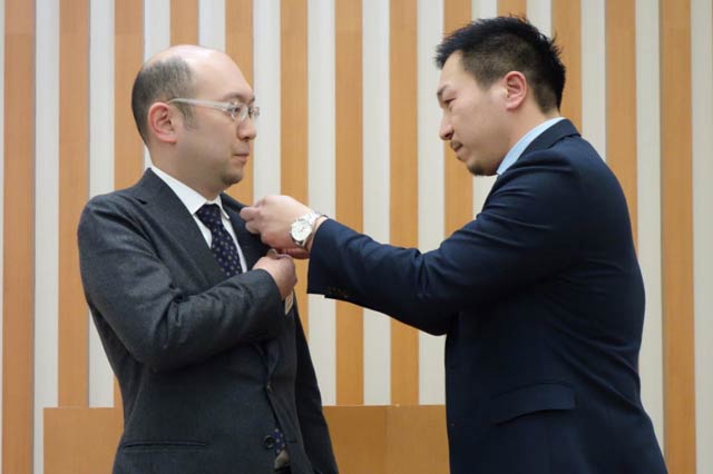 佐藤会長から曽根次年度会長へ会長バッジを引き継ぐ