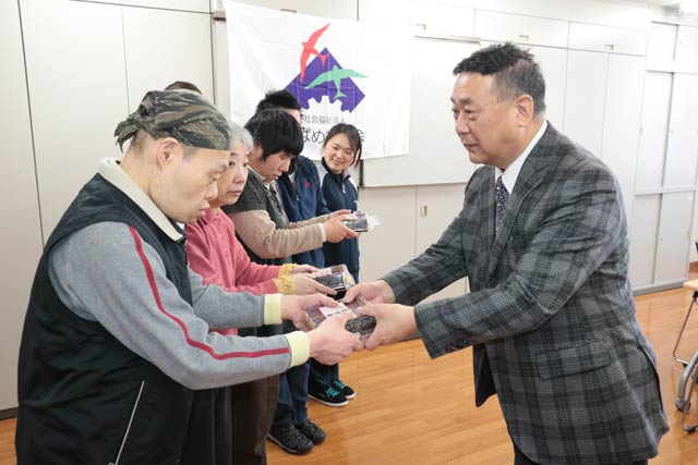 恵方巻を利用者に手渡すローソン燕杣木店のオーナー長岡さん
