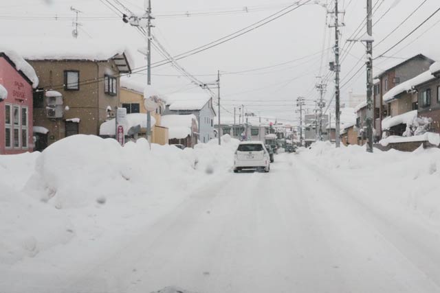 まるで豪雪地域のように高い雪の壁ができた燕市新町の通り