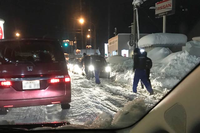 ガスト三条須頃店前の県道256号では自動車販売店の社員が立ち往生する車を次々と脱出させた