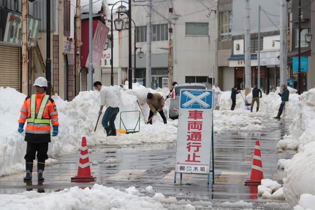 商店主らも外に出て雪を溶かす