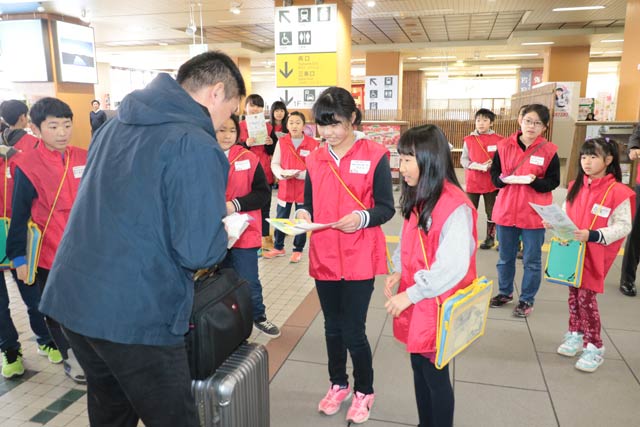 燕三条駅で下車した乗客に自分たちで育てた特別栽培米「分北米」を手渡す分水北小5年生